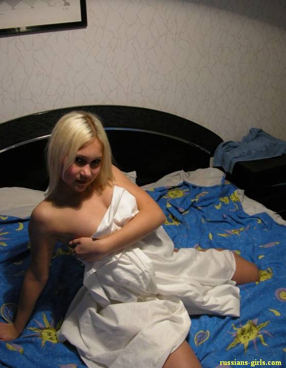 На кровати девушка позирует раздетой