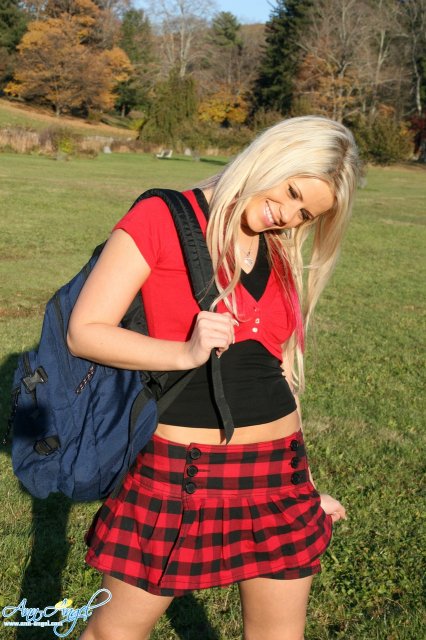 Сексуальная блондинка школьница позирует на природе снимая одежду